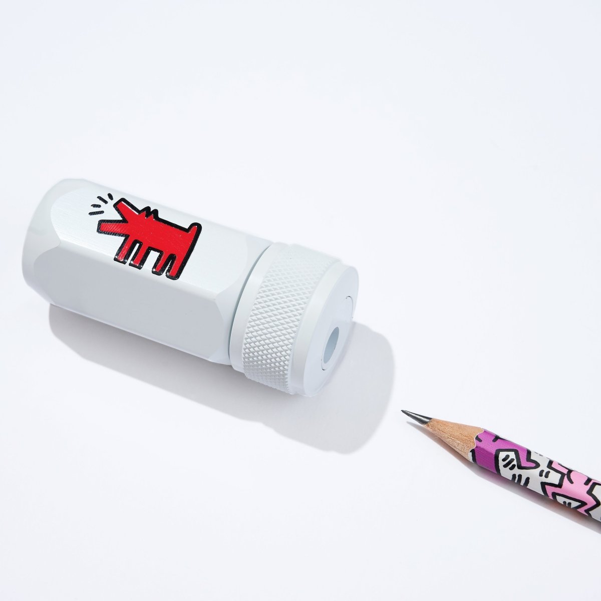 Side view of the sharpener next to a Blackwing pencil with Keith Haring artwork.