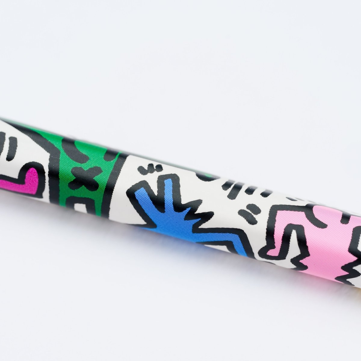 Close-up of one pencil tip with bold line art in blue and pink from Haring’s illustrations.