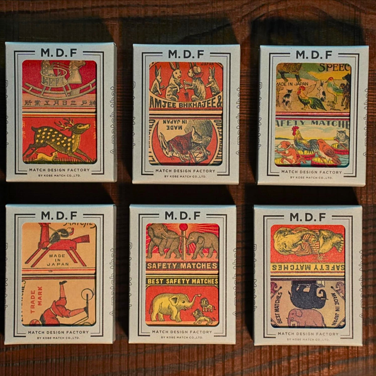 Collection of M.D.F. matchboxes with vintage designs on a wooden surface