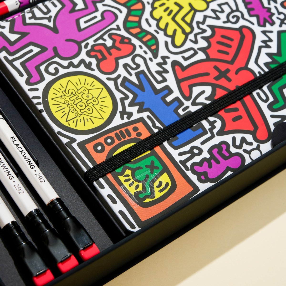 Close-up of the sketchbook and pencils inside the gift box highlighting bright artwork and design details.