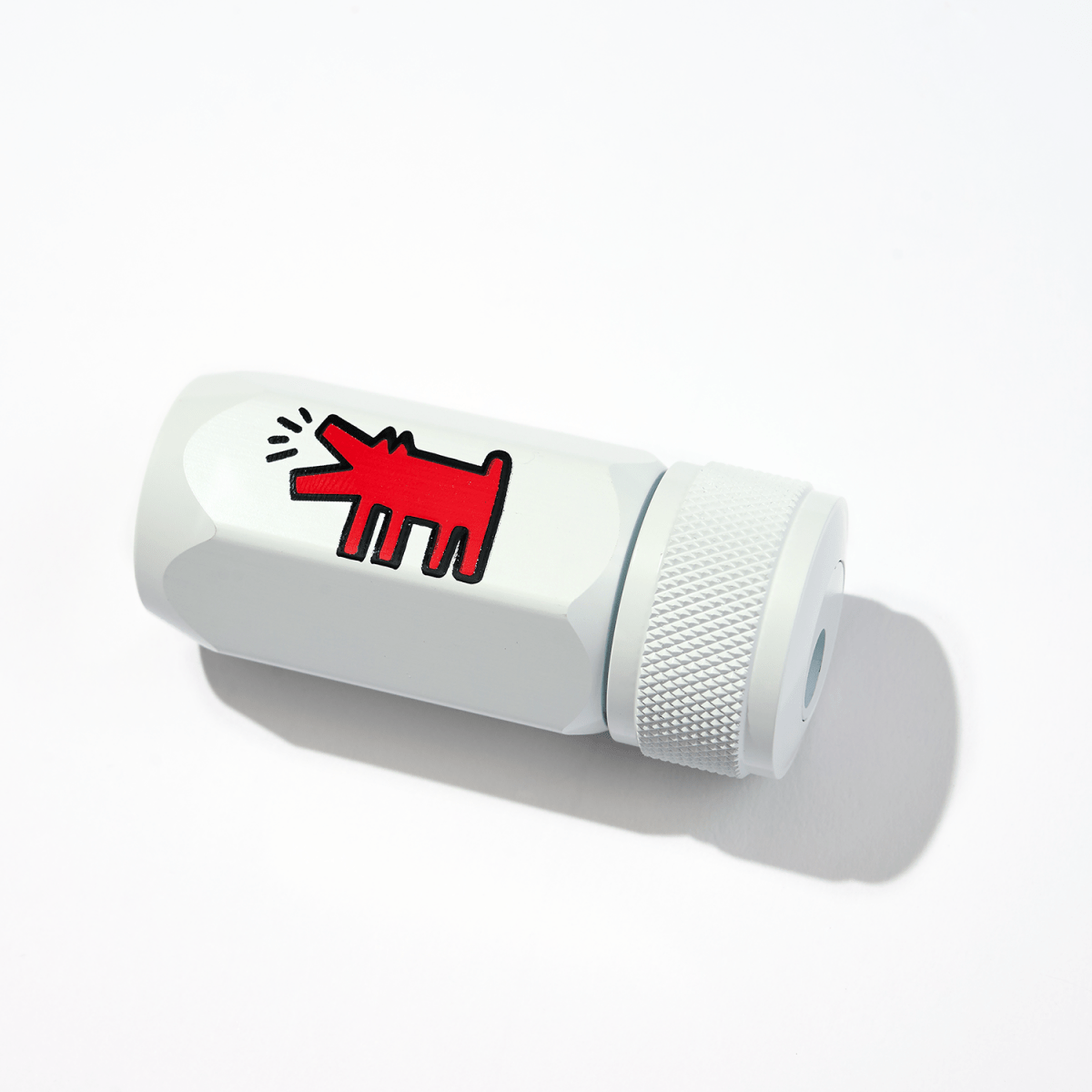 Close-up of the Blackwing One-Step Sharpener in white, featuring Keith Haring’s iconic red dog illustration.