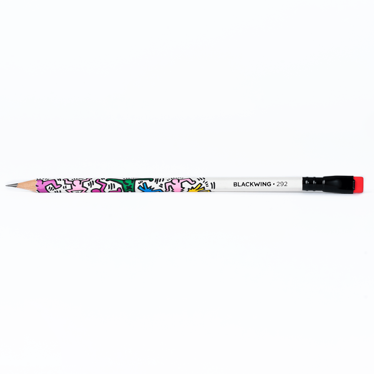 Full side view of a single Blackwing Volume 292 pencil featuring Keith Haring artwork with a red eraser.