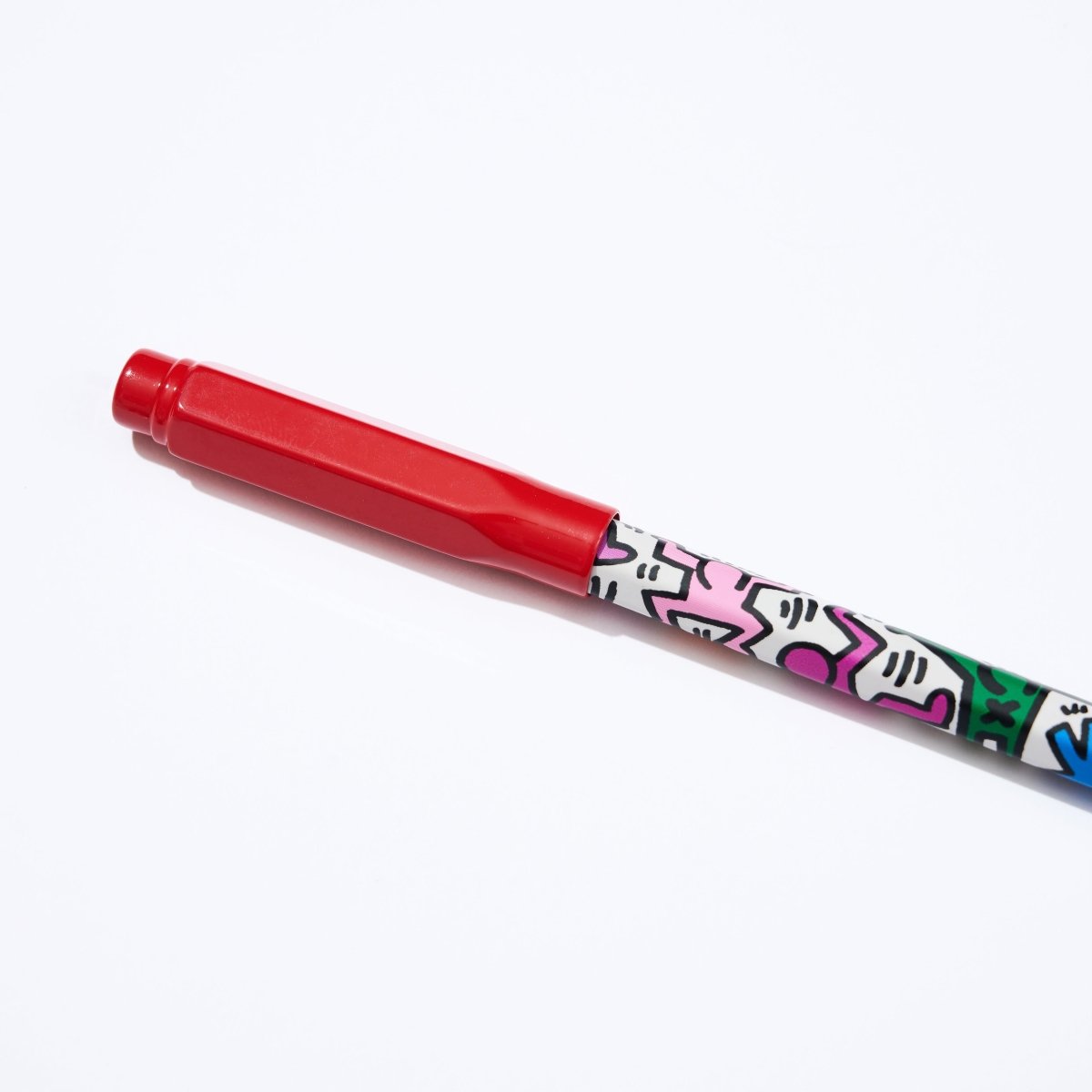 Close-up of the Blackwing “Radiant Heart” red point guard fitted onto a Keith Haring Volume 292 pencil featuring bold, colourful artwork.