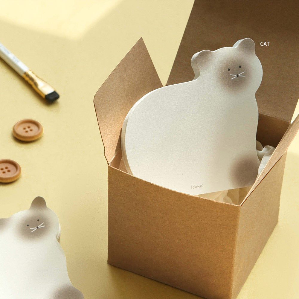 A white brown cat-shaped Iconic Animal Memo Pad placed inside a small box with stationery around it.