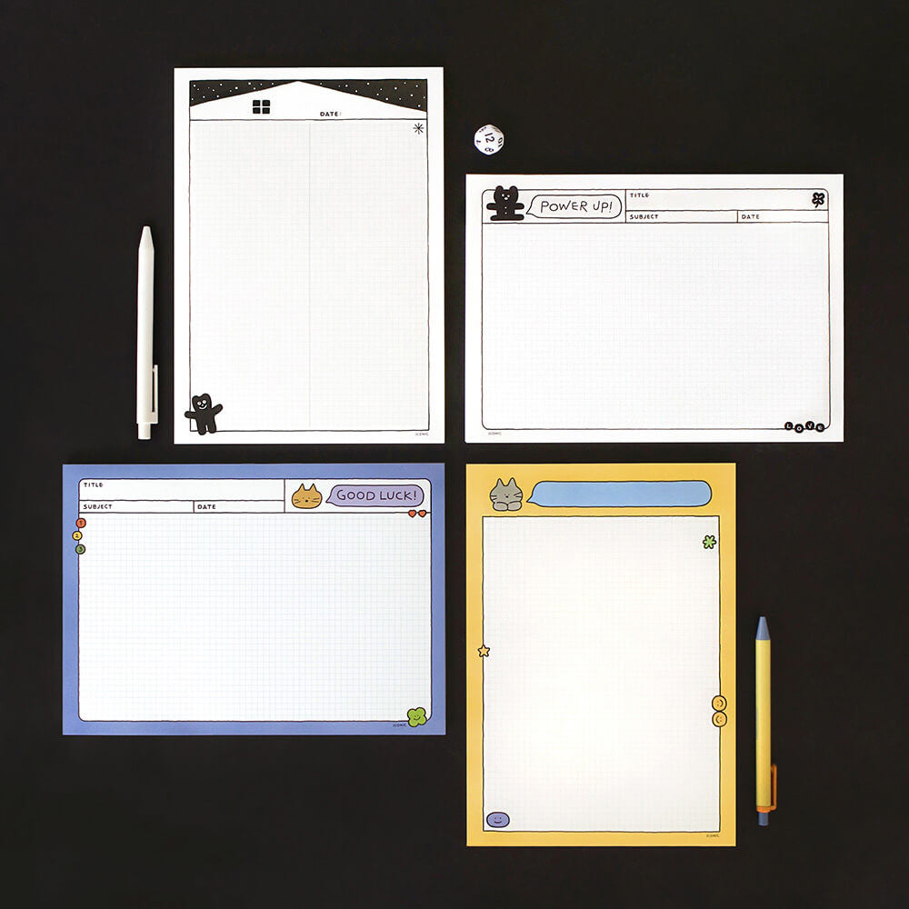 Iconic B5 Doodle Grid Notepads in assorted colours displayed flat on desk with pens and stationery.