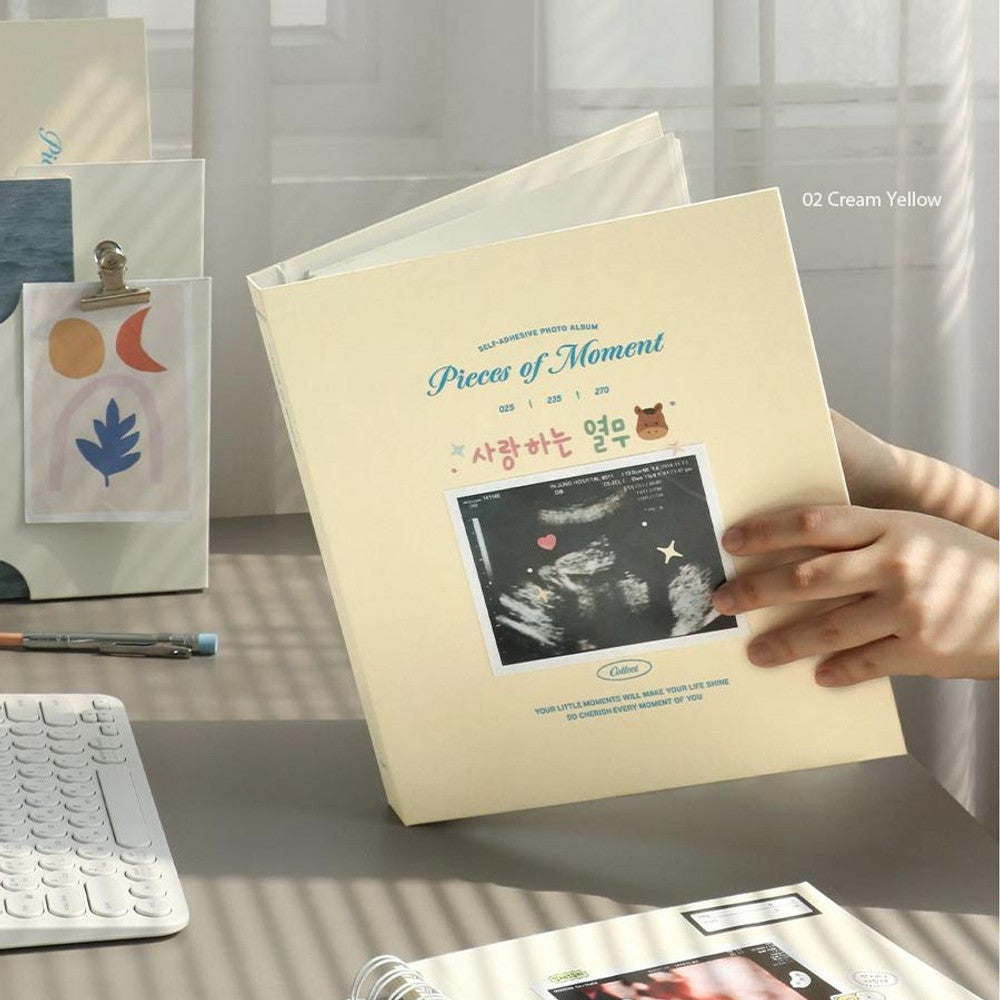 Iconic Collect Self-Adhesive Photo Album in cream yellow cover shown in use with hands placing photo inside.