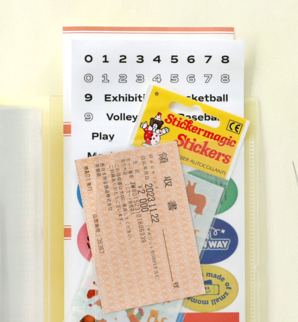 Iconic Collect Ticket Book 64 pockets in cream yellow with tickets stored inside.