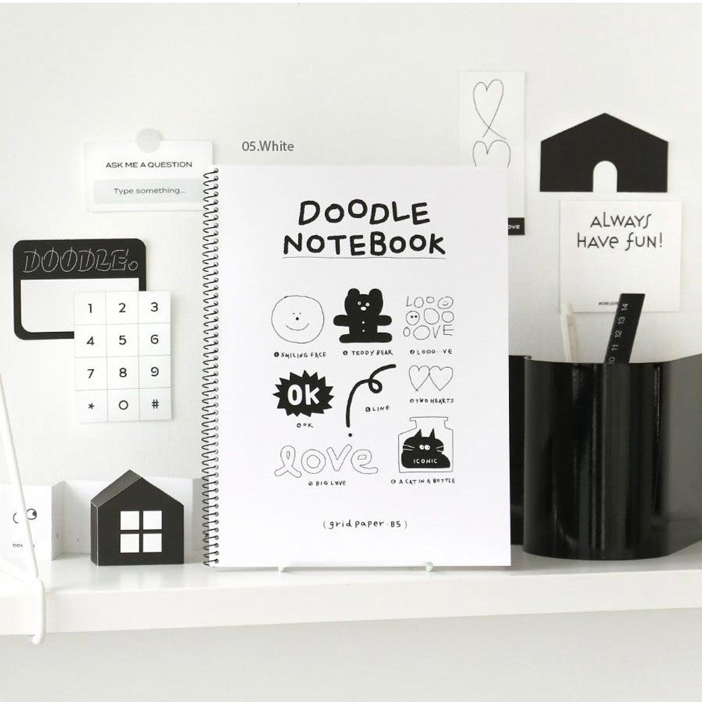 Iconic Doodle B5 Grid Notebook in white cover displayed on desk with stationery and ruler.