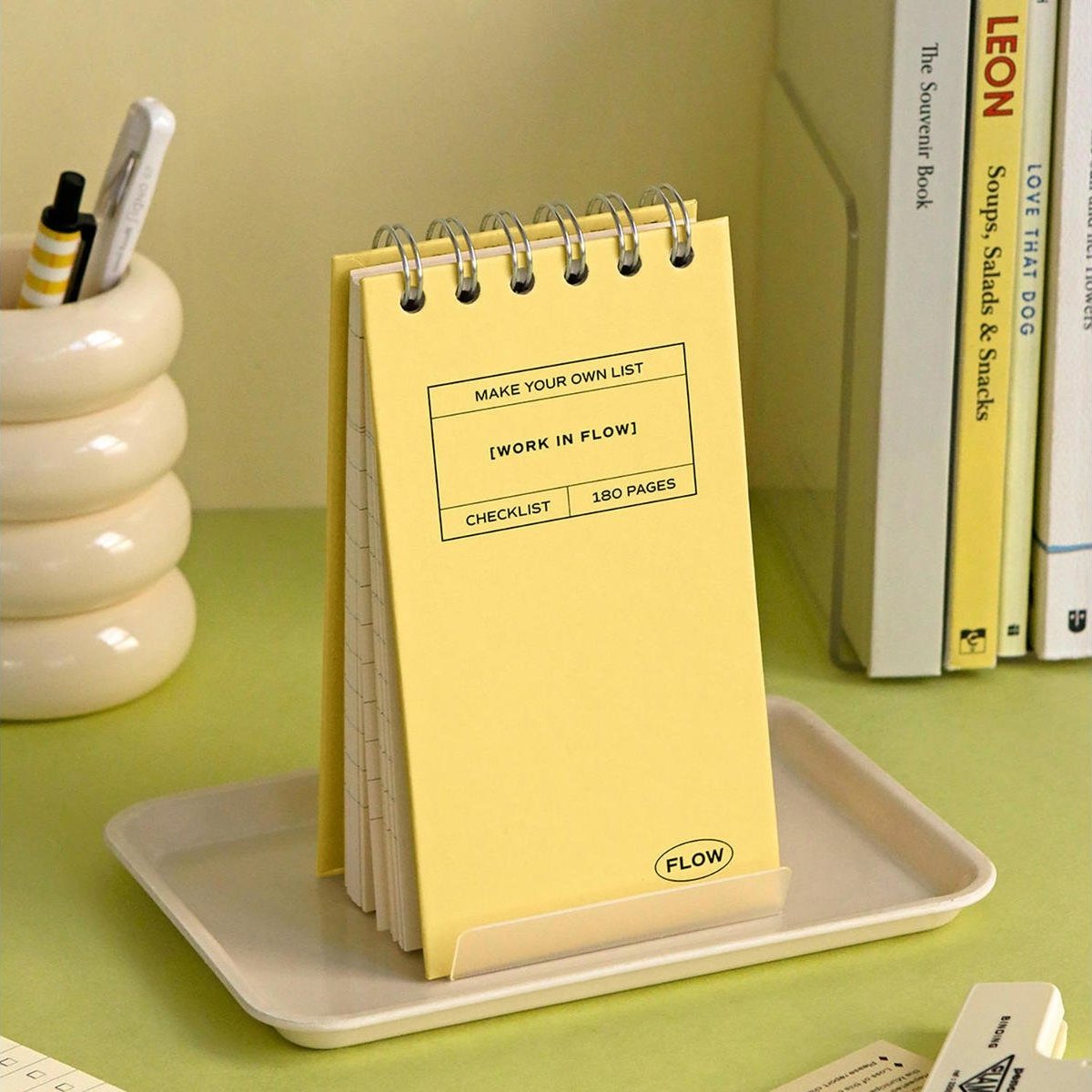 A yellow Iconic Flow Checklist placed on a beige tray with pen holder in the back.