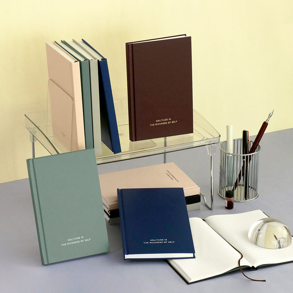 Iconic Solitude Tomoe River Line Notebooks in assorted colours displayed on desk with stationery.