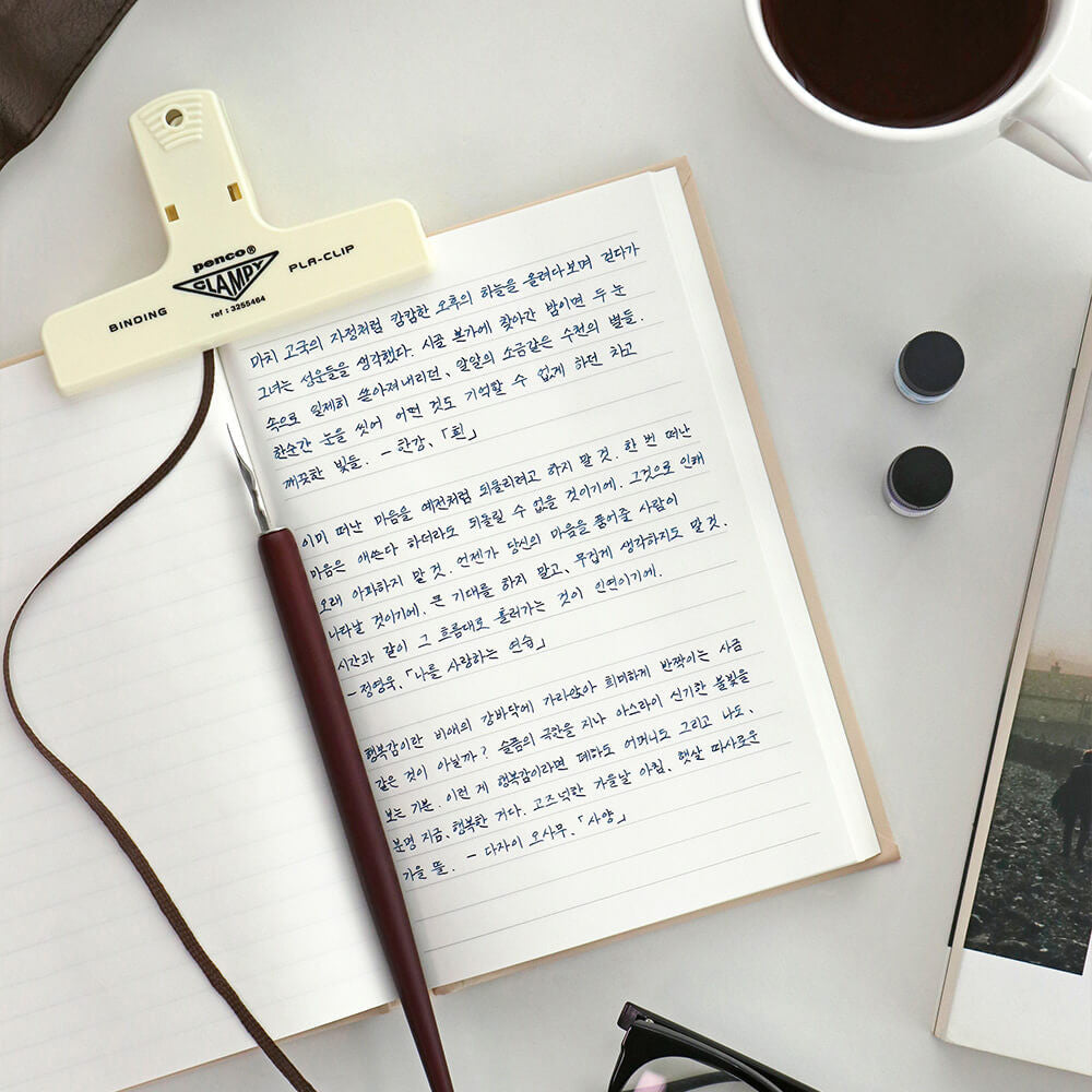 Iconic Solitude Tomoe River Line Notebook open on desk with pen and handwritten notes.