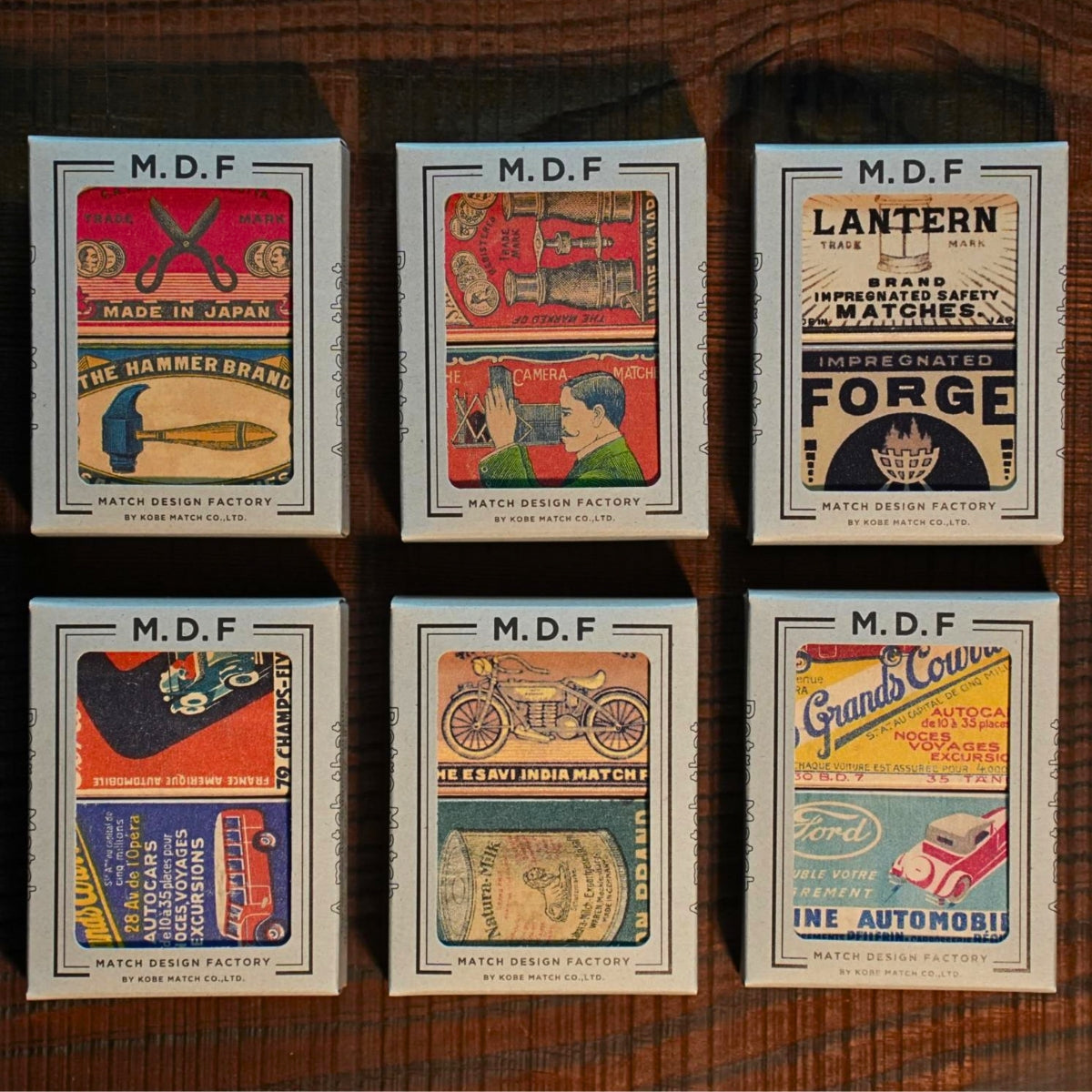 Collection of M.D.F. matchboxes with vintage design on a wooden surface